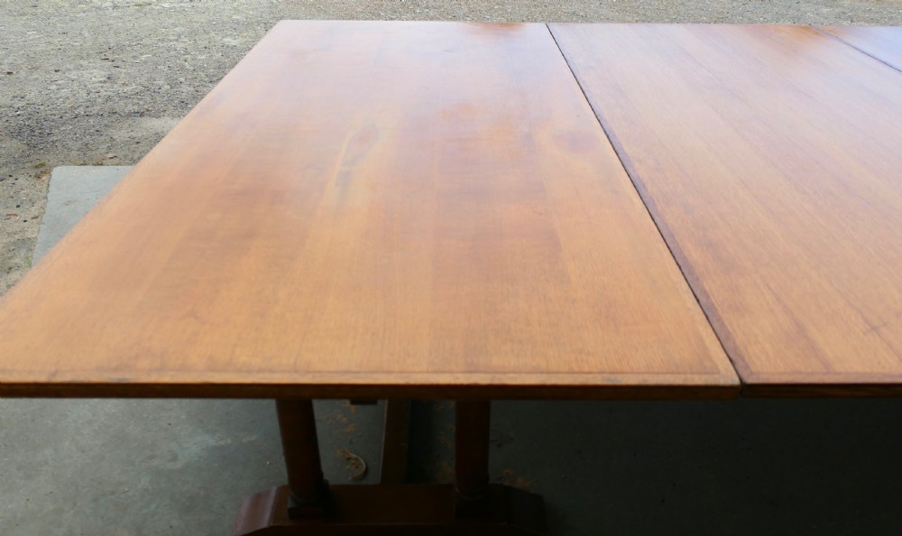 An exceptionally long Arts and Crafts solid oak banqueting table supported by columned trestle bases and structural stretchers. View III