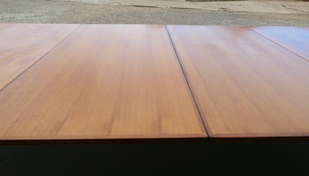 An exceptionally long Arts and Crafts solid oak banqueting table supported by columned trestle bases and structural stretchers. View V