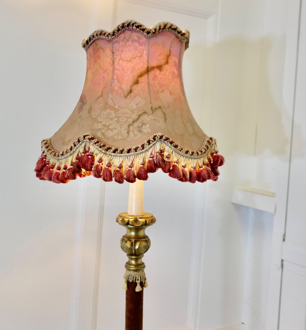 An antique French floor lamp with a gilded metal base, a velvet-wrapped central column, and a pink fabric lampshade featuring detailed fringe tassels. View V
