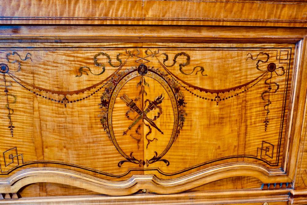 A French satin walnut jardiniere featuring intricate marquetry inlay of swags, bow motifs, and a central torch medallion, raised on square tapered legs. View II