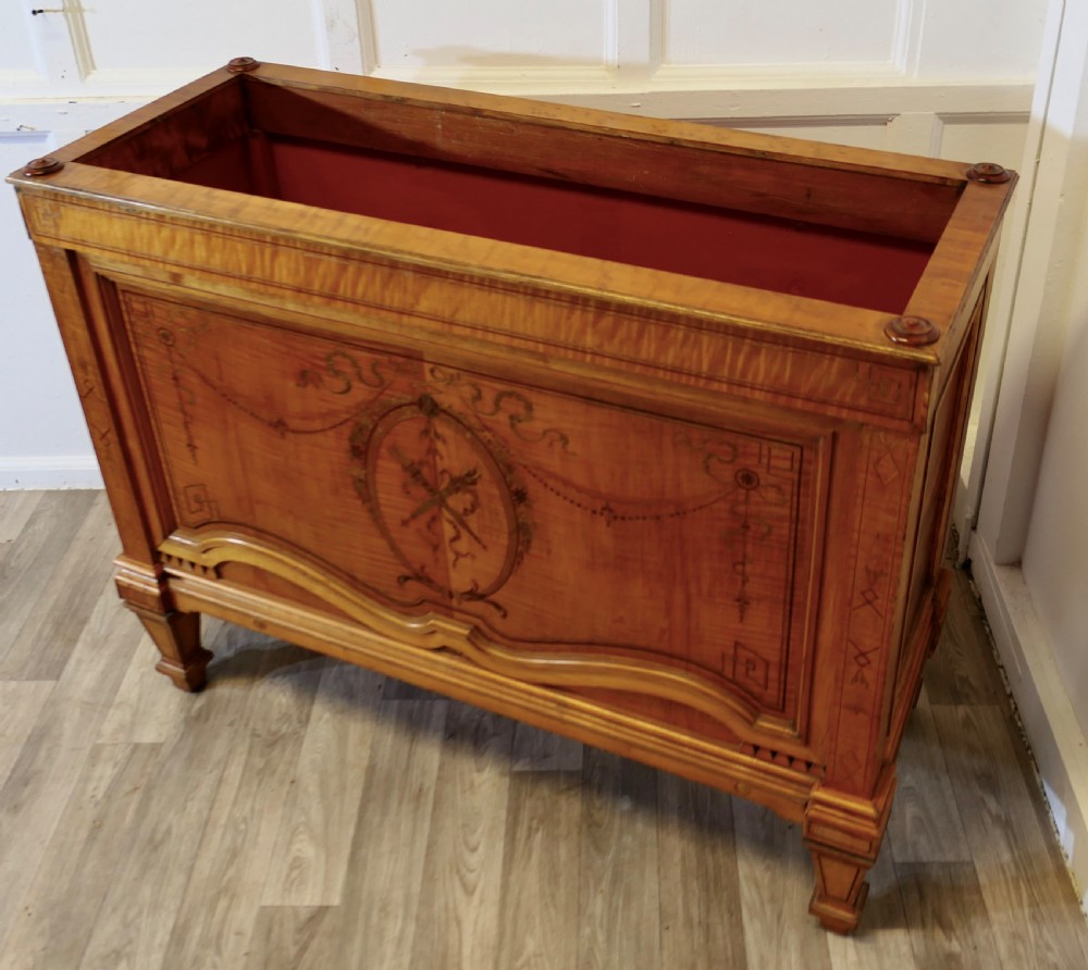 A French satin walnut jardiniere featuring intricate marquetry inlay of swags, bow motifs, and a central torch medallion, raised on square tapered legs. View III