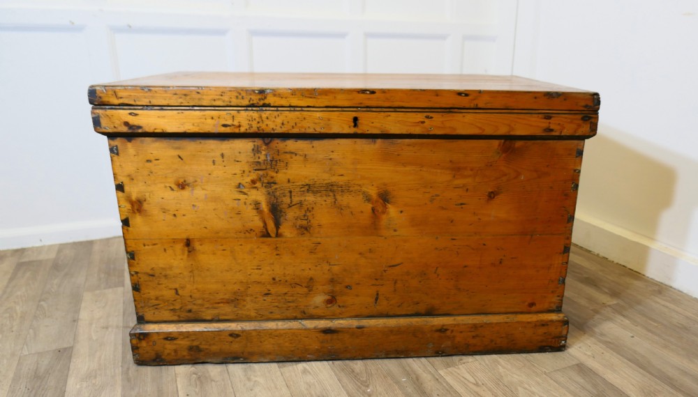 A rectangular Victorian pine carpenters chest featuring visible dovetail joinery, a hinged lid, and a keyhole escutcheon.