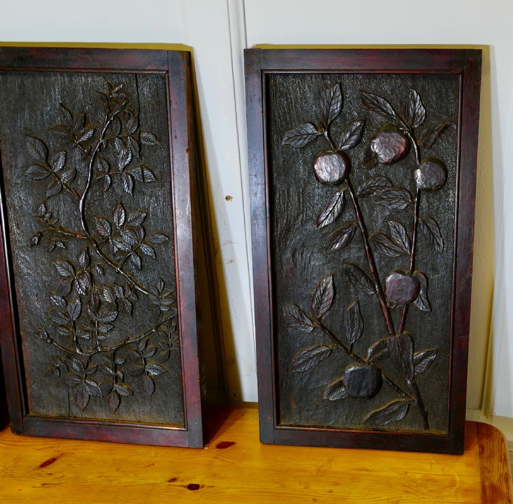 A set of four dark brown hand-carved oak panels featuring detailed botanical and floral relief motifs framed in rectangular timber borders. View II