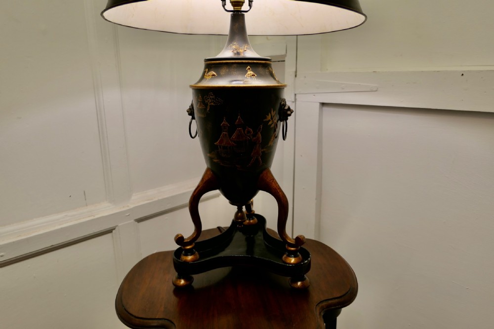 A black and gold lacquered Chinoiserie toleware table lamp decorated with oriental motifs, featuring lion head ring handles, tripod cabriole legs, and a conical metal shade. View VI
