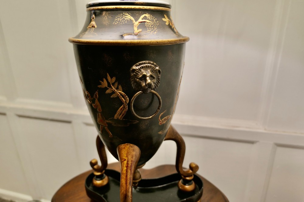 A black and gold lacquered Chinoiserie toleware table lamp decorated with oriental motifs, featuring lion head ring handles, tripod cabriole legs, and a conical metal shade. View VII