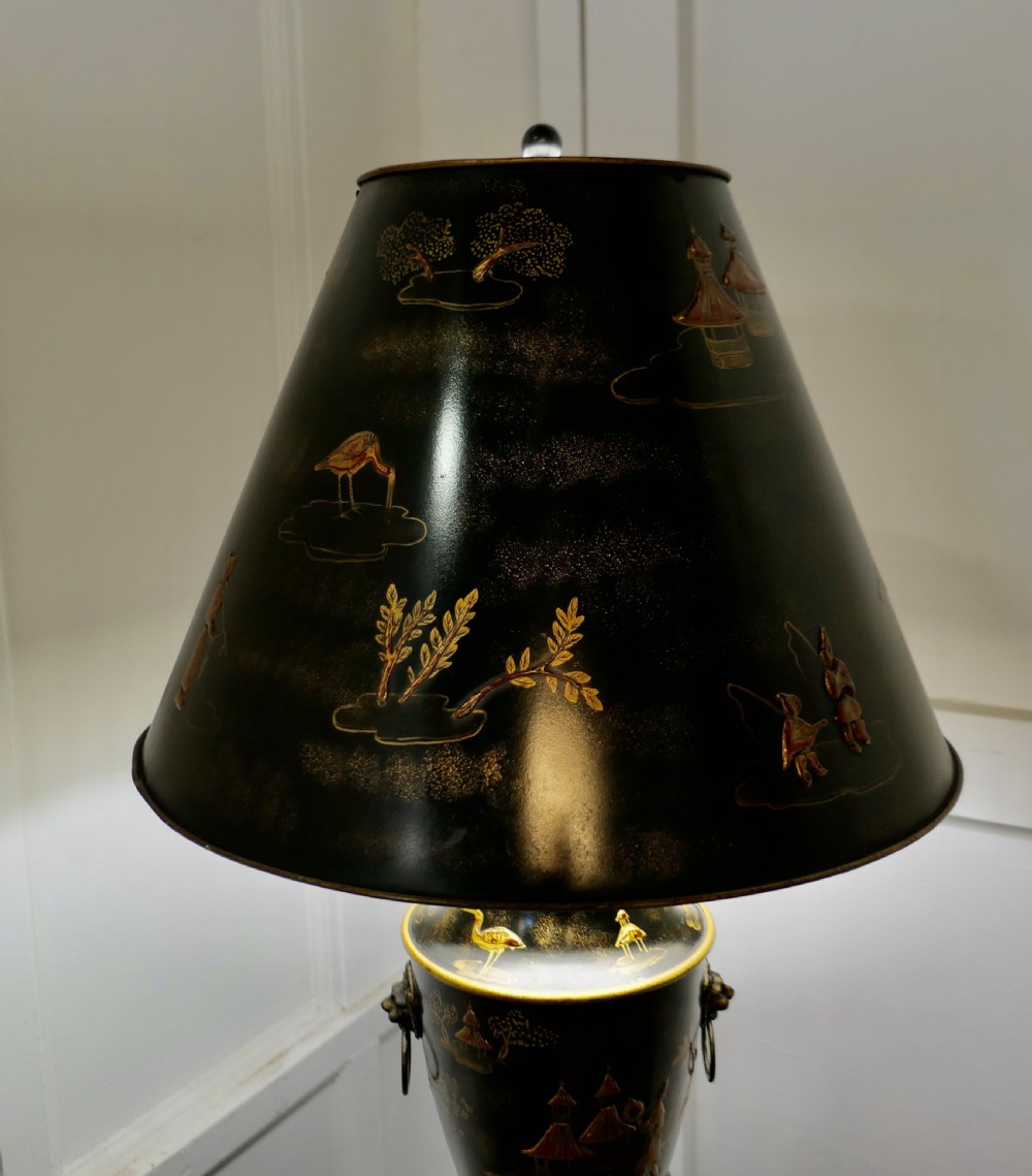 A black and gold lacquered Chinoiserie toleware table lamp decorated with oriental motifs, featuring lion head ring handles, tripod cabriole legs, and a conical metal shade. View VIII