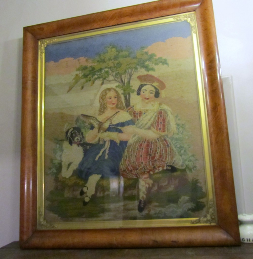 A nineteenth-century framed Scottish wool needlepoint picture depicting figures in Highland dress with a dog set within a wide cushion-moulded maple frame. View II