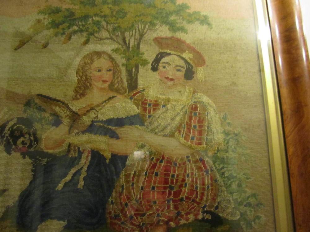 A nineteenth-century framed Scottish wool needlepoint picture depicting figures in Highland dress with a dog set within a wide cushion-moulded maple frame. View V