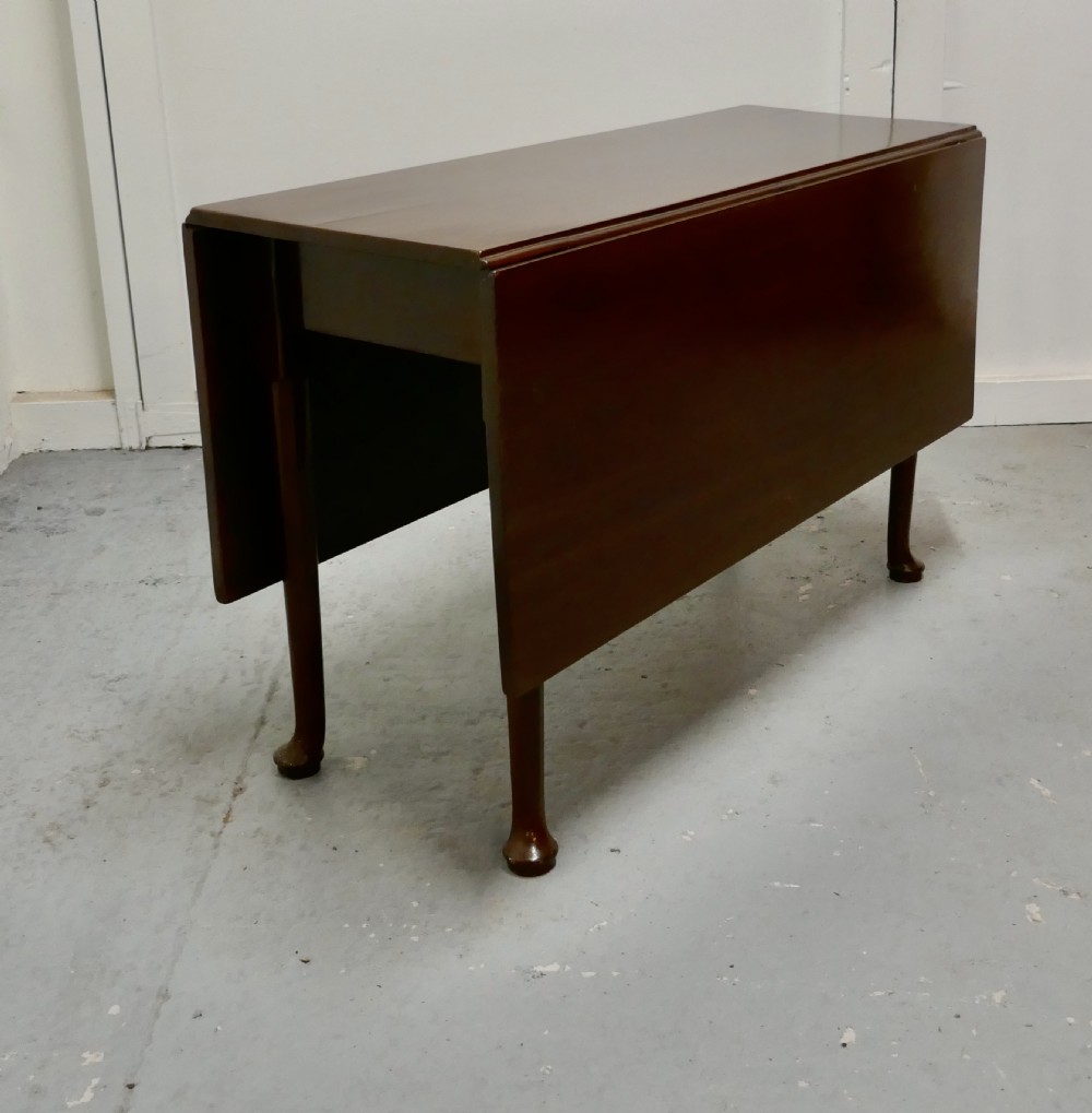 Folded Georgian mahogany drop-leaf dining table with straight turned legs terminating in pad feet. View II