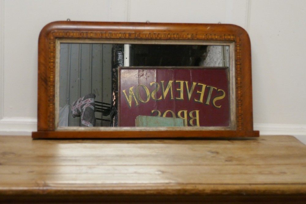 A Victorian walnut overmantel mirror featuring rounded upper corners, an intricate mosaic Tunbridge ware inlay border, and a gilt inner slip frame.