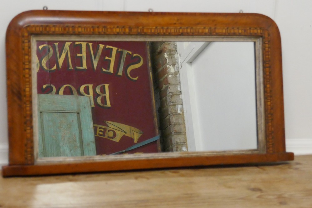 A Victorian walnut overmantel mirror featuring rounded upper corners, an intricate mosaic Tunbridge ware inlay border, and a gilt inner slip frame. View VI
