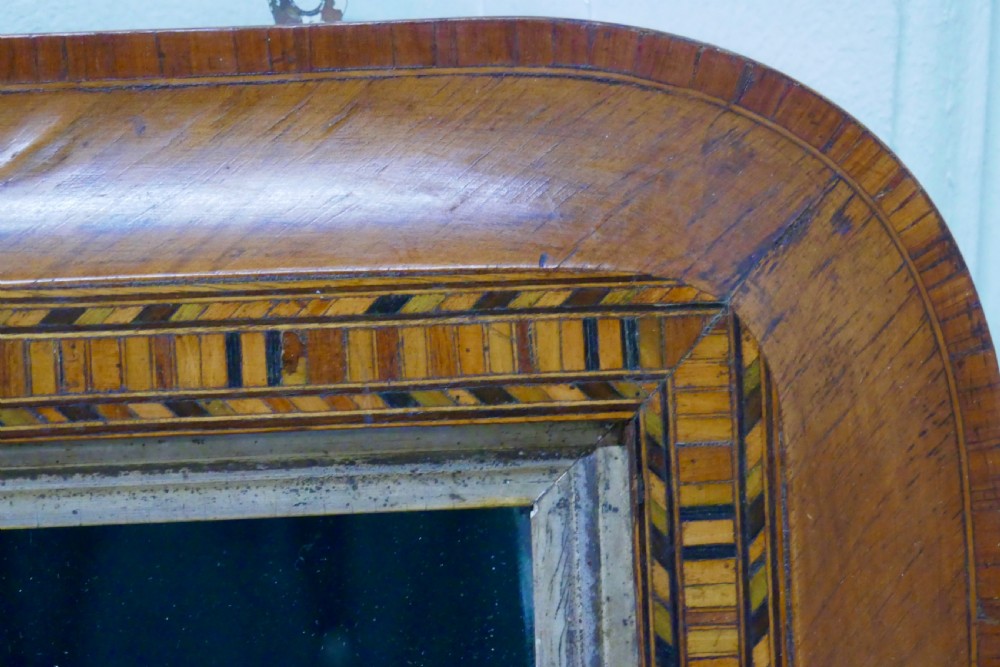 A Victorian walnut overmantel mirror featuring rounded upper corners, an intricate mosaic Tunbridge ware inlay border, and a gilt inner slip frame. View VII