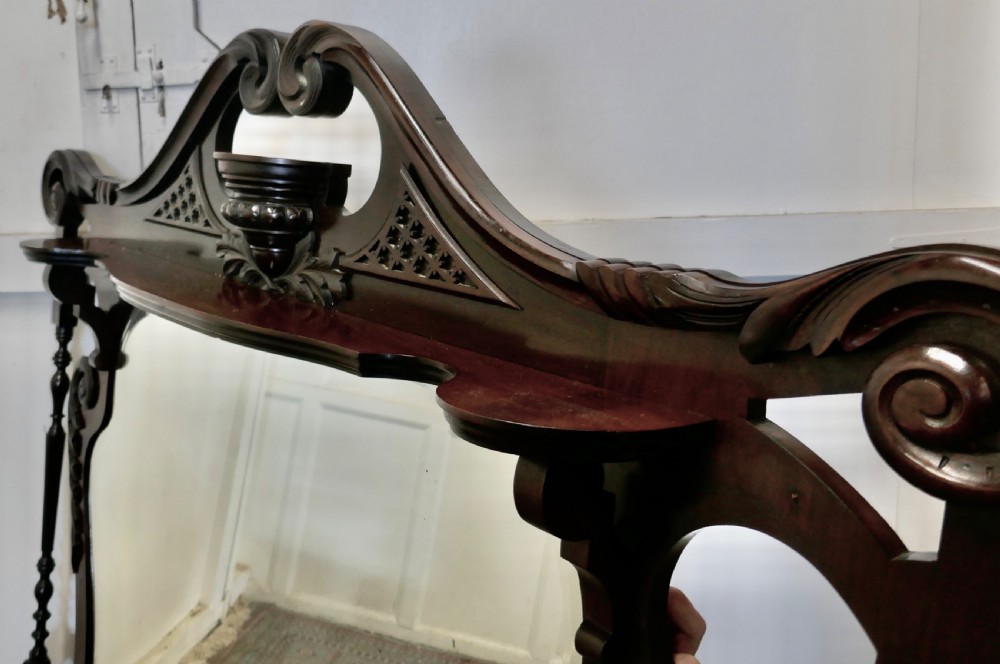 A large carved mahogany overmantel mirror in the Chinese Chippendale style, featuring pierced fretwork, turned side supports, side display shelves, and a shaped glass plate. View V