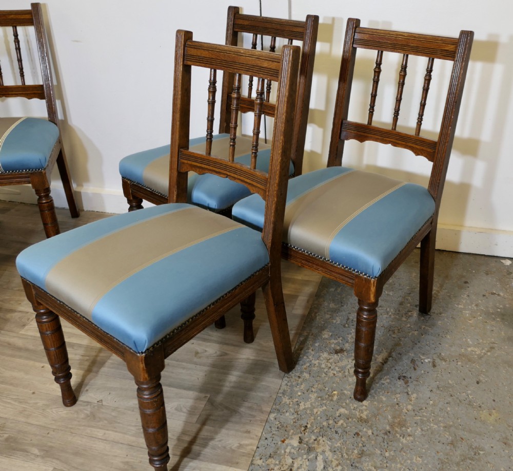 A set of six Edwardian oak dining chairs featuring turned front legs, vertical back spindles, and blue and grey striped satin seats with stud detail. View IV