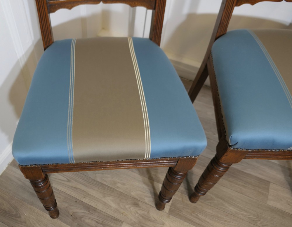 A set of six Edwardian oak dining chairs featuring turned front legs, vertical back spindles, and blue and grey striped satin seats with stud detail. View IX