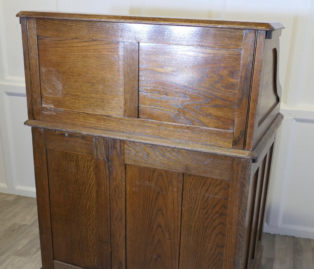 An Art Deco oak roll top desk featuring a flexible tambour shutter, fitted internal cubbies, and a single pedestal with four stacked drawers. View VIII