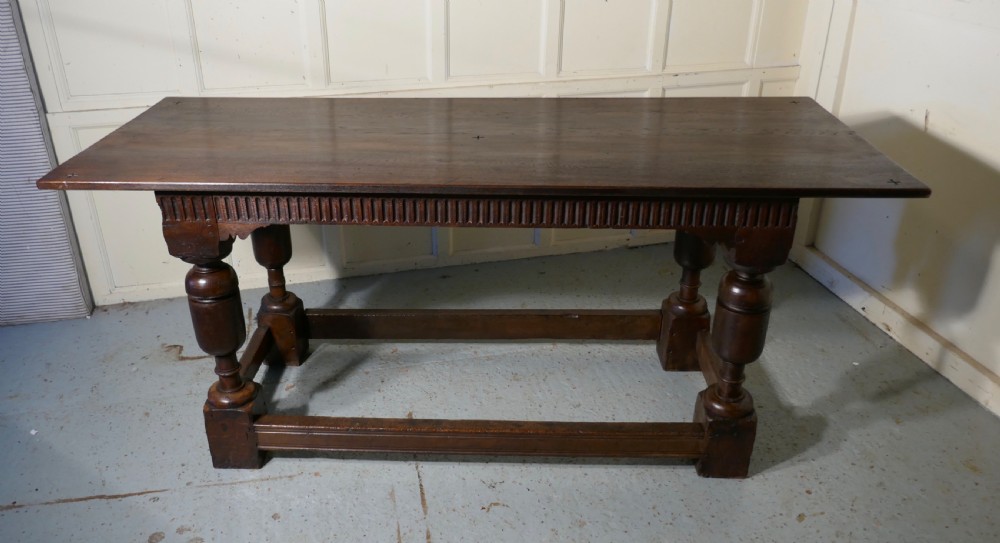 A 19th-century dark oak refectory table featuring turned legs, a carved fluted apron, and a low box stretcher. View II