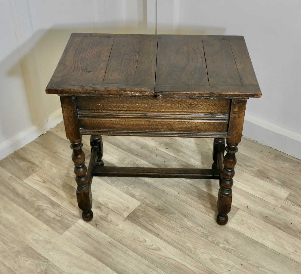 A dark oak joint stool featuring a rectangular plank top, a moulded frieze, turned legs, and a low perimeter stretcher base. View II