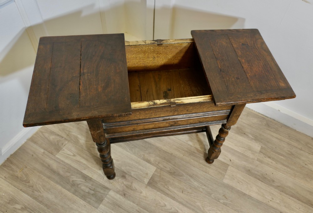 A dark oak joint stool featuring a rectangular plank top, a moulded frieze, turned legs, and a low perimeter stretcher base. View VIII
