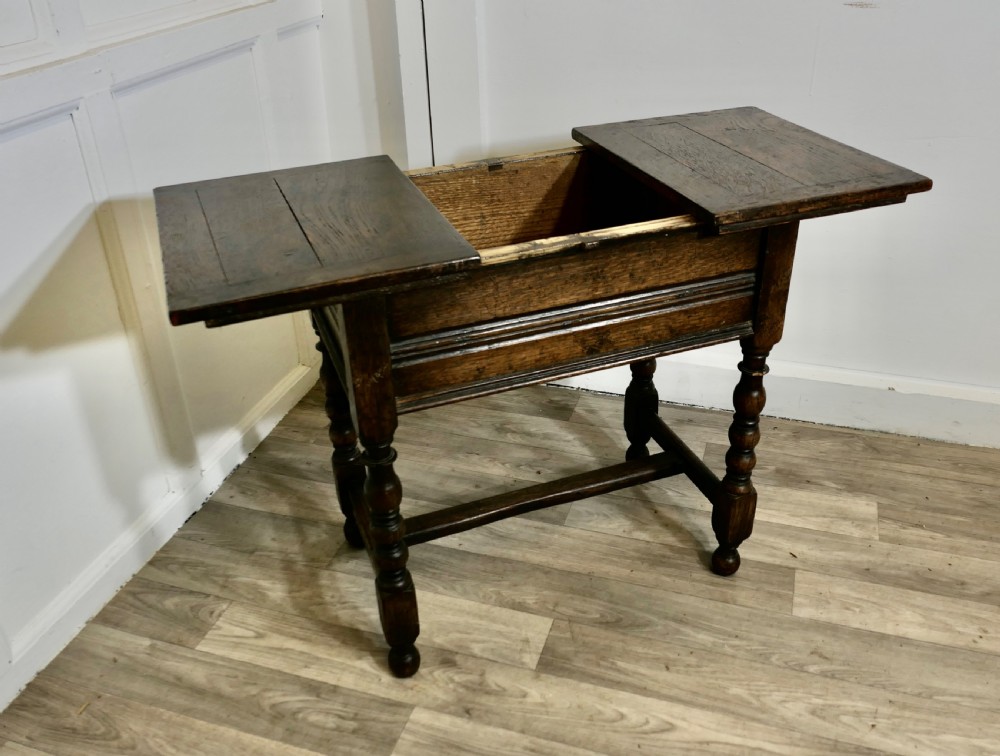 A dark oak joint stool featuring a rectangular plank top, a moulded frieze, turned legs, and a low perimeter stretcher base. View IX