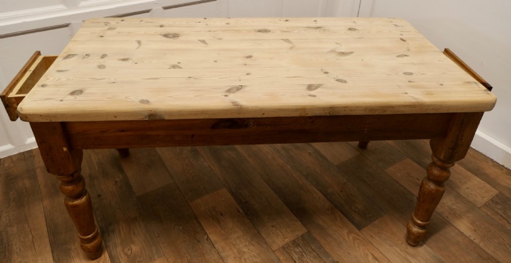 A rectangular pine kitchen table with a scrubbed natural wood top, turned legs, and a single drawer with a wooden knob pull. View III