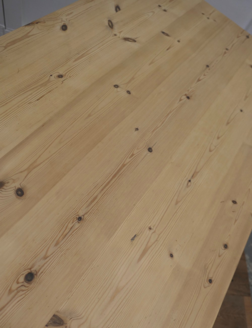 A rectangular pine kitchen table with a scrubbed natural wood top, turned legs, and a single drawer with a wooden knob pull. View VI