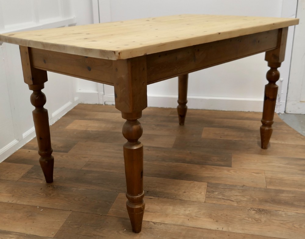 A rectangular pine kitchen table with a scrubbed natural wood top, turned legs, and a single drawer with a wooden knob pull. View VIII