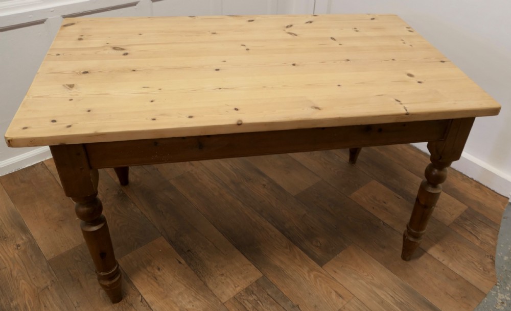 A rectangular pine kitchen table with a scrubbed natural wood top, turned legs, and a single drawer with a wooden knob pull. View IX