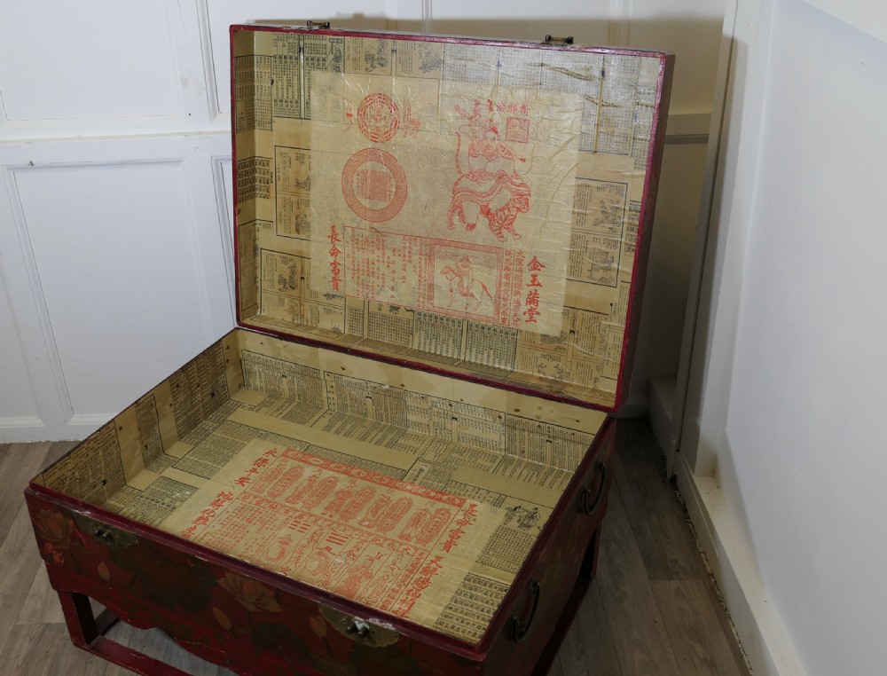 A red painted Chinoiserie marriage chest decorated with lotus motifs, raised on a low timber stand with brass clasps. View VII