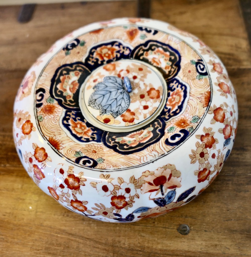 A Japanese Imari porcelain vase converted into a table lamp with a cream conical shade, positioned beside a matching decorated lidded bowl. View VI
