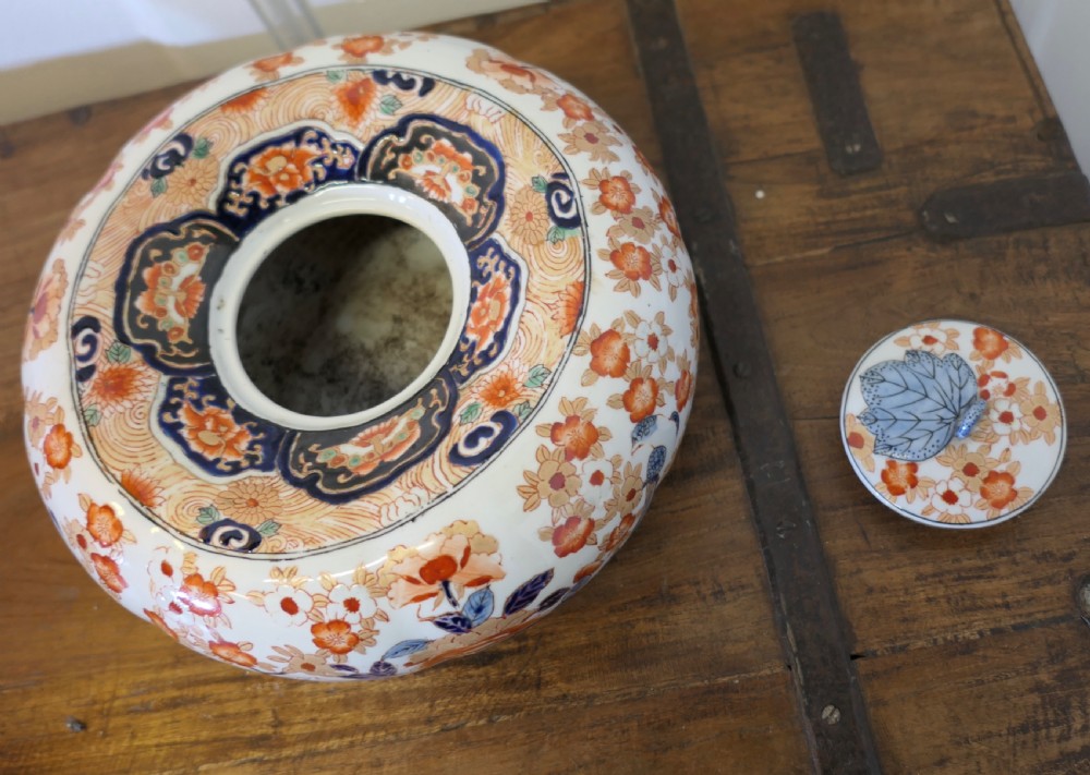 A Japanese Imari porcelain vase converted into a table lamp with a cream conical shade, positioned beside a matching decorated lidded bowl. View VIII