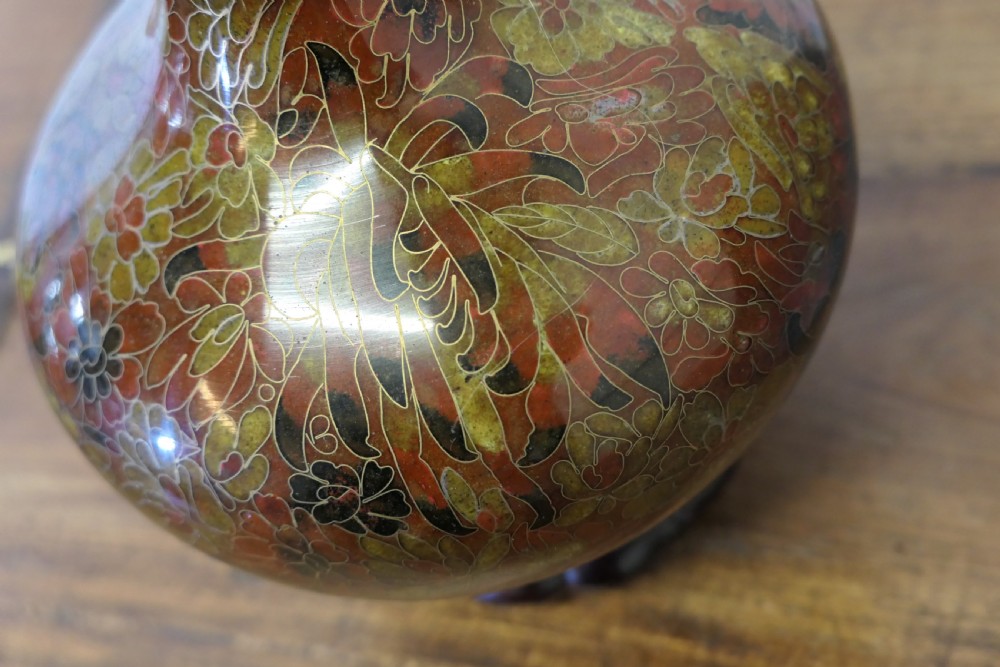 A baluster-shaped cloisonne table lamp featuring floral enamelling and a carved dark wood stand under a textured brown fabric lampshade. View VIII