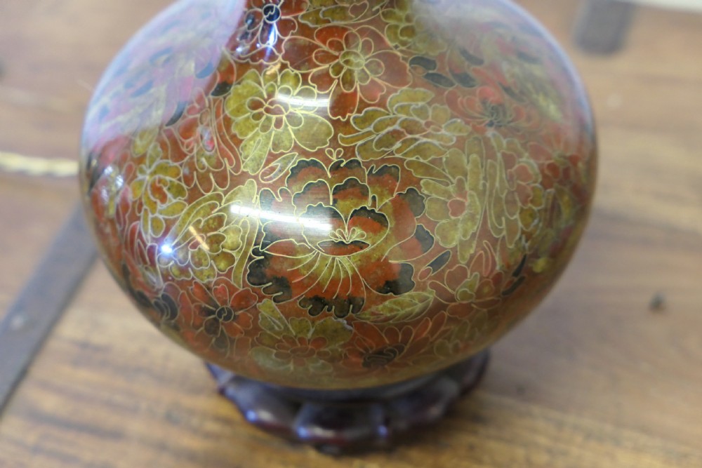 A baluster-shaped cloisonne table lamp featuring floral enamelling and a carved dark wood stand under a textured brown fabric lampshade. View IX