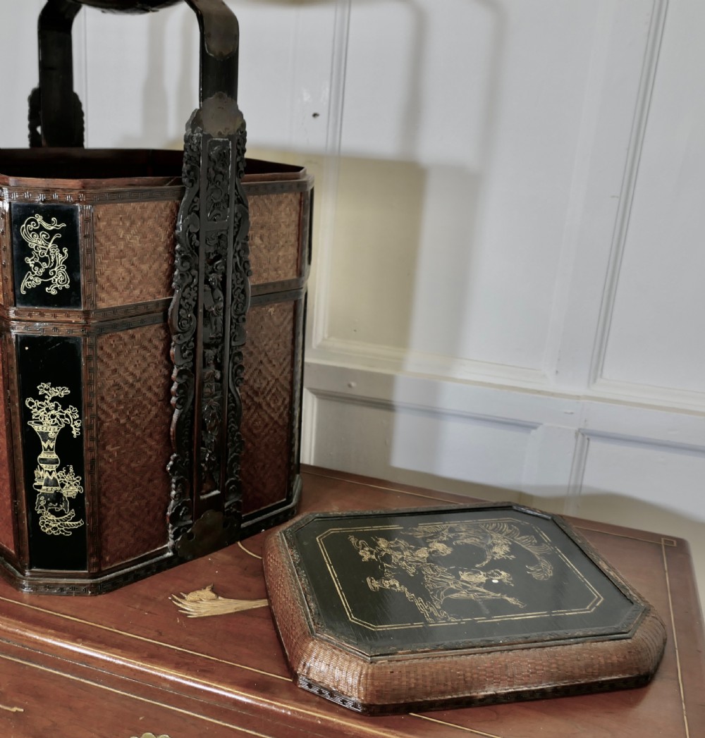 An octagonal Chinese wedding basket constructed from woven bamboo and dark lacquered wood with a tall overhead handle and double doors at the base. View V