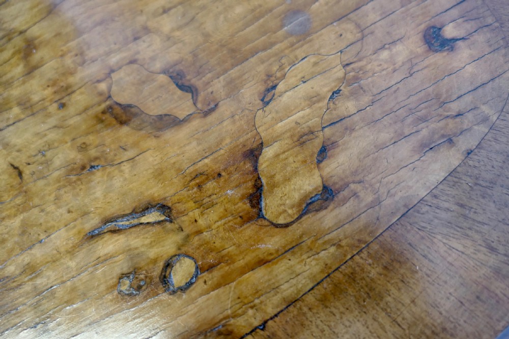 An antique carved walnut occasional table featuring a shaped serpentine top, cabriole legs, and an ornamental carved X-frame stretcher. View VI