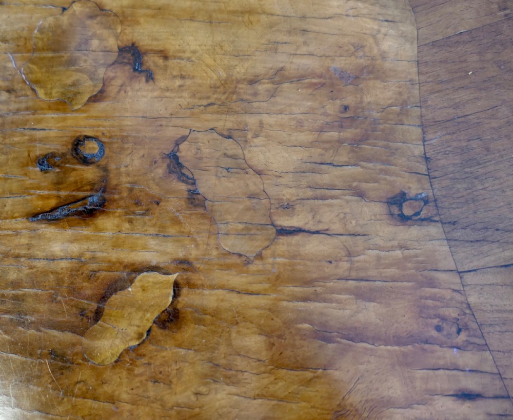 An antique carved walnut occasional table featuring a shaped serpentine top, cabriole legs, and an ornamental carved X-frame stretcher. View IX