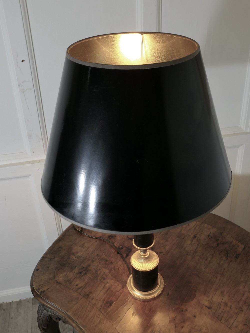 An Art Deco table lamp featuring a tapered black leather stem, a black conical shade, and turned brass fittings. View VI