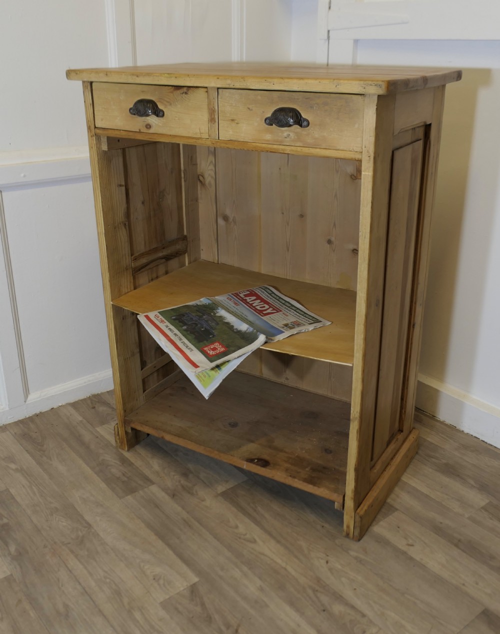 A tall standing pine desk featuring two upper drawers with dark metal cup handles above open lower shelving and panelled sides. View II