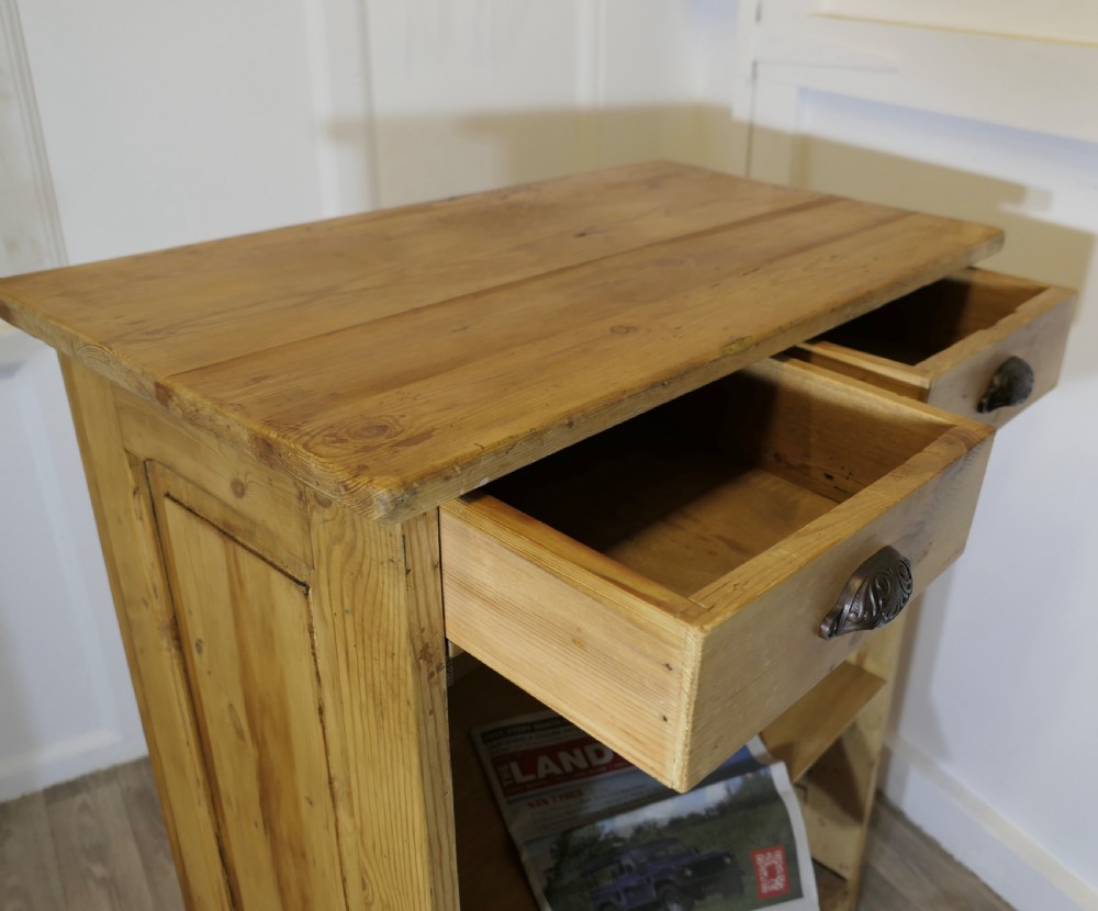 A tall standing pine desk featuring two upper drawers with dark metal cup handles above open lower shelving and panelled sides. View IV