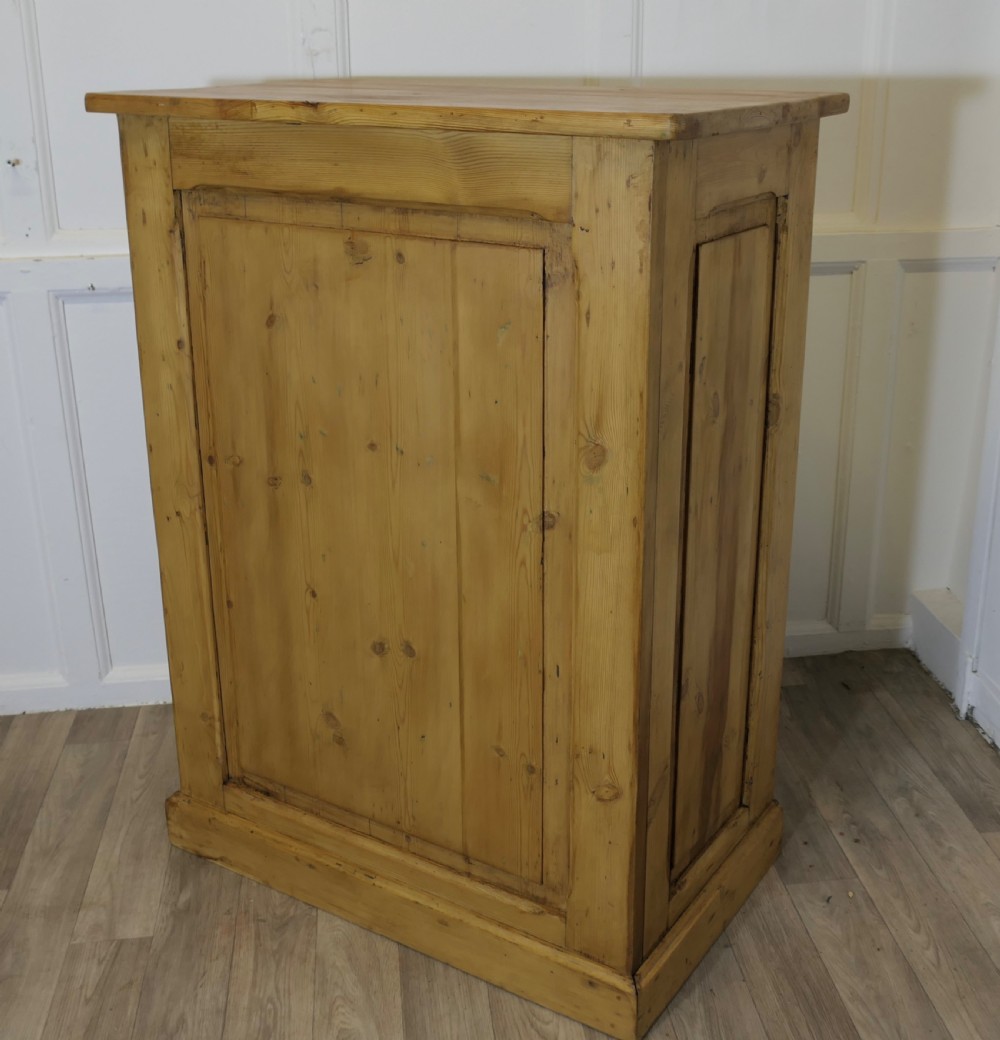 A tall standing pine desk featuring two upper drawers with dark metal cup handles above open lower shelving and panelled sides. View V
