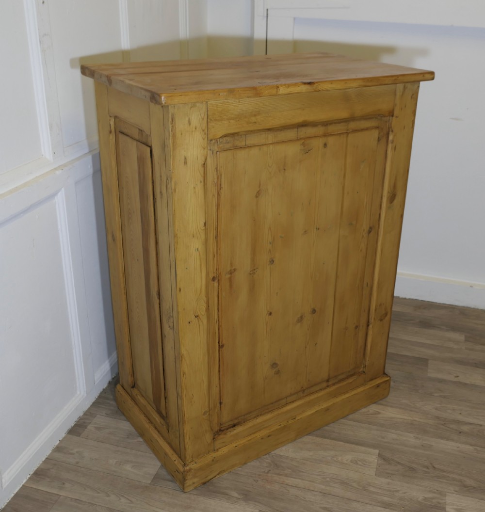 A tall standing pine desk featuring two upper drawers with dark metal cup handles above open lower shelving and panelled sides. View VII