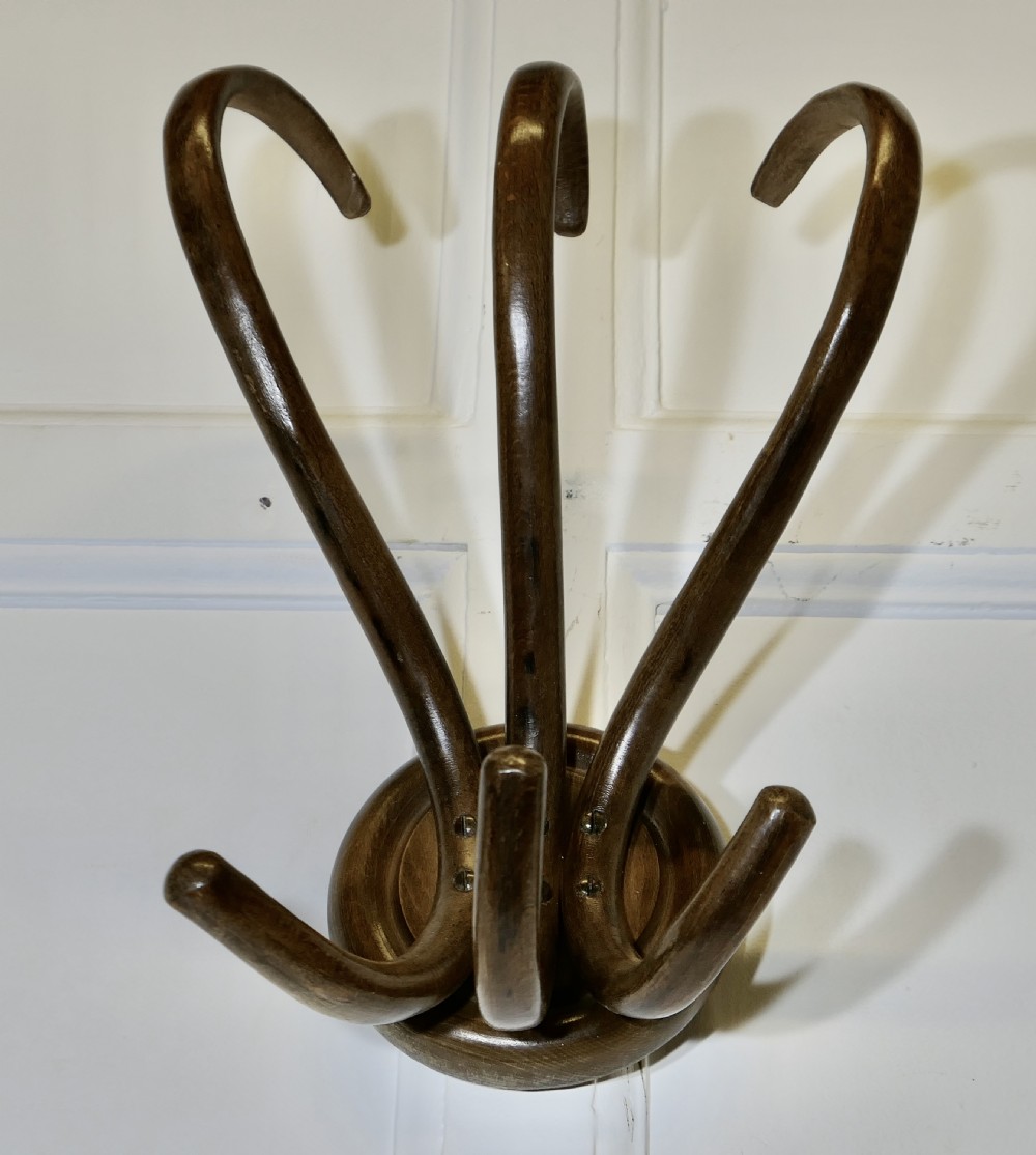 A dark brown bentwood wall-mounted coat rack featuring three sweeping upper hooks and three smaller lower hooks attached to a central circular base. View II