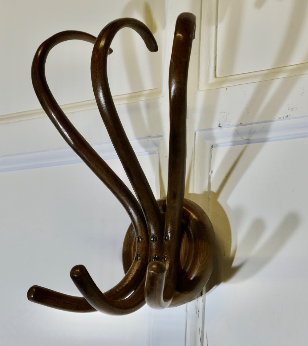 A dark brown bentwood wall-mounted coat rack featuring three sweeping upper hooks and three smaller lower hooks attached to a central circular base. View IV