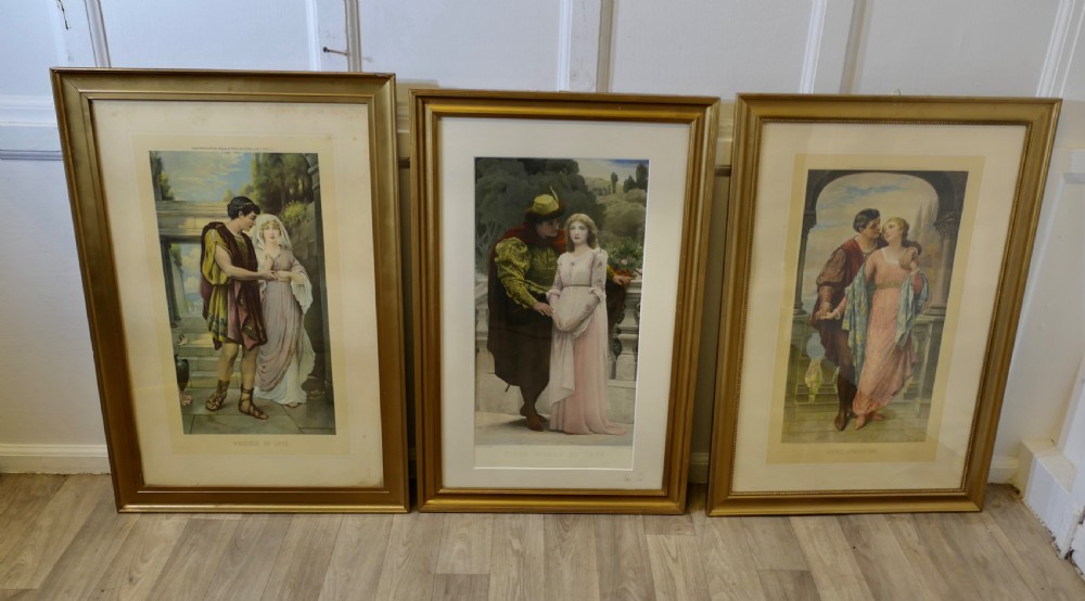A set of three 19th-century framed Pre-Raphaelite style prints displaying romantic couples in classical attire within gilded frames.