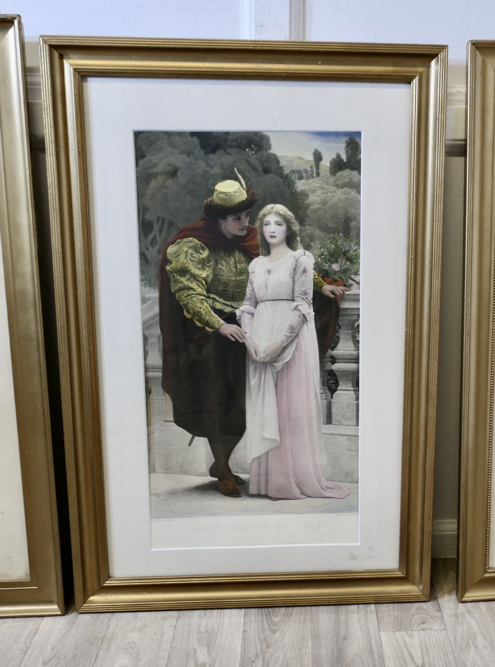 A set of three 19th-century framed Pre-Raphaelite style prints displaying romantic couples in classical attire within gilded frames. View III