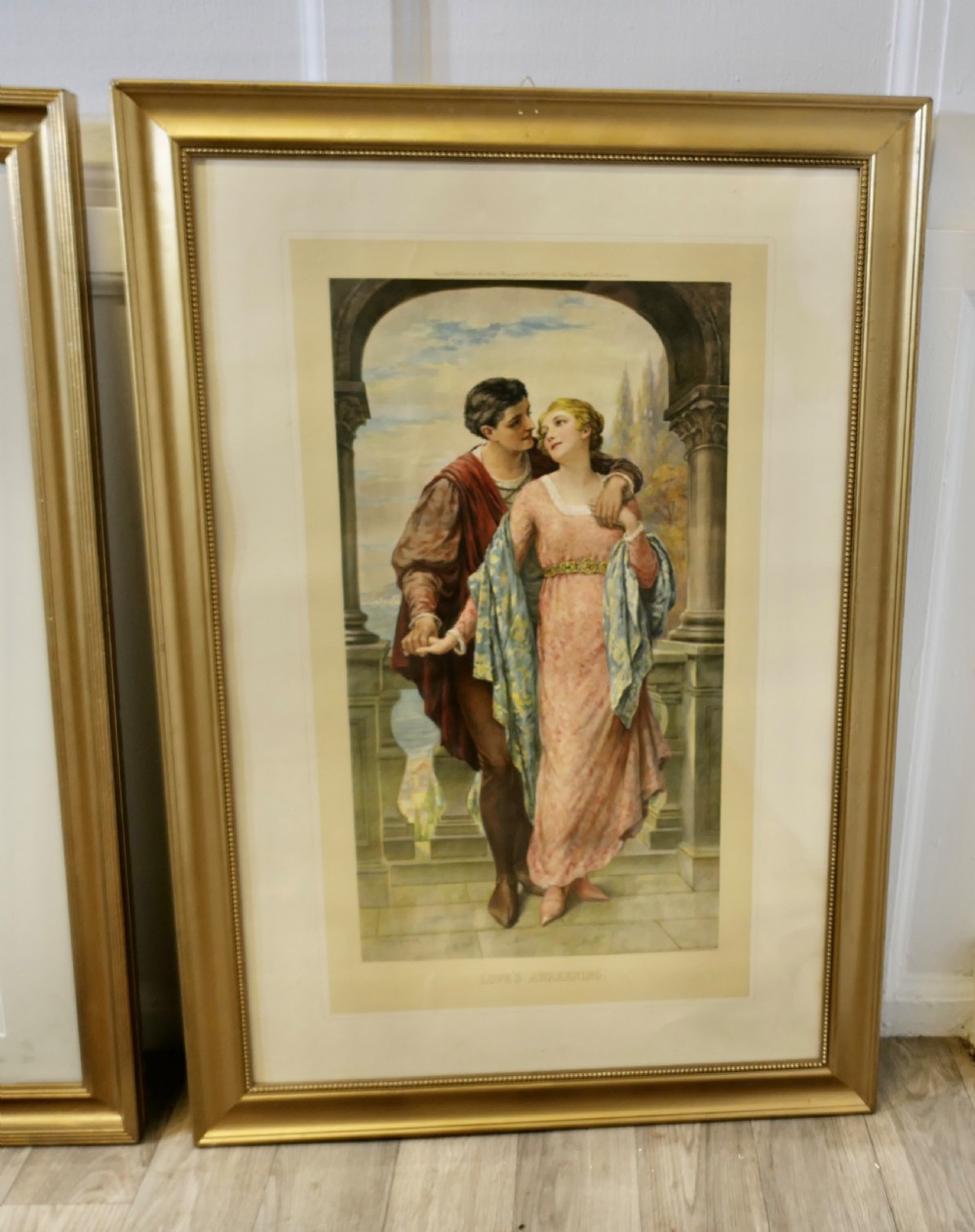 A set of three 19th-century framed Pre-Raphaelite style prints displaying romantic couples in classical attire within gilded frames. View IV