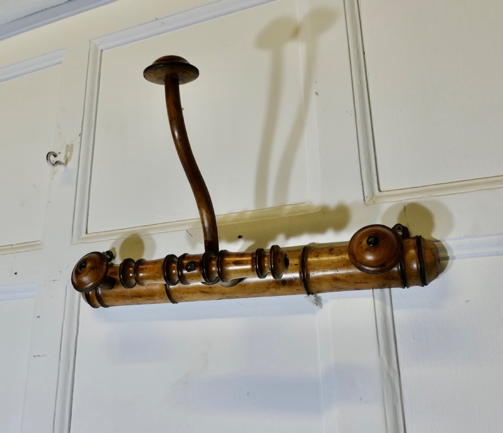 An antique French wall-mounted coat rack crafted from turned wood carved in a simulated bamboo design with turned hanging pegs. View III