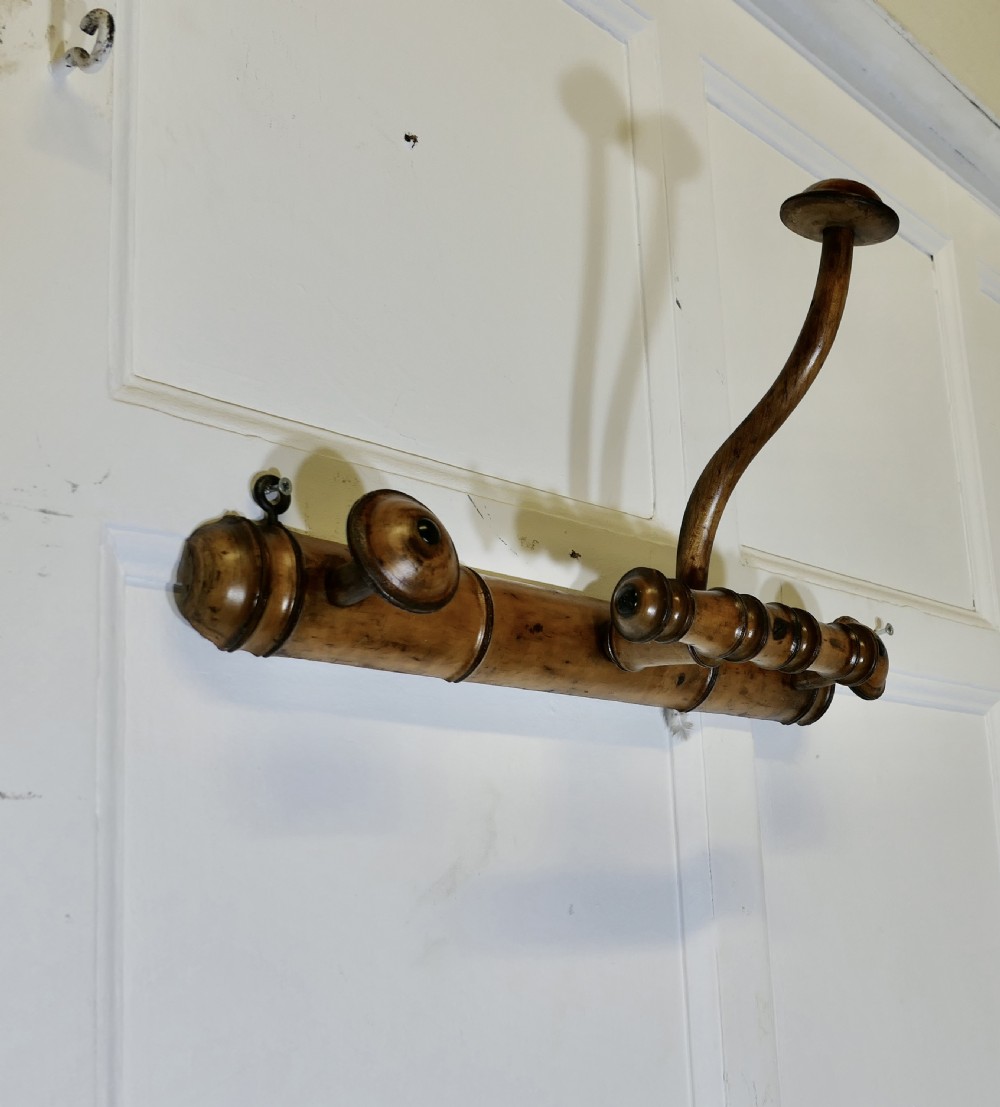 An antique French wall-mounted coat rack crafted from turned wood carved in a simulated bamboo design with turned hanging pegs. View IV