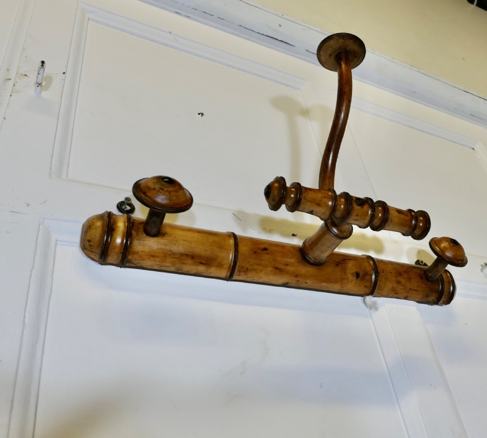 An antique French wall-mounted coat rack crafted from turned wood carved in a simulated bamboo design with turned hanging pegs. View VI