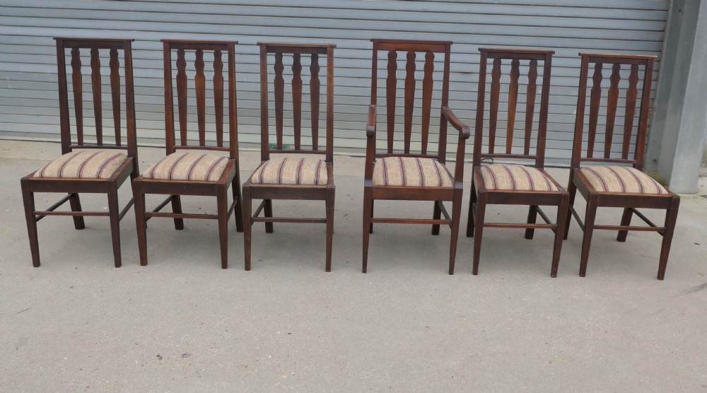 A set of six dark oak Arts and Crafts dining chairs featuring high vertical slat backs and striped fabric drop-in seats. View II